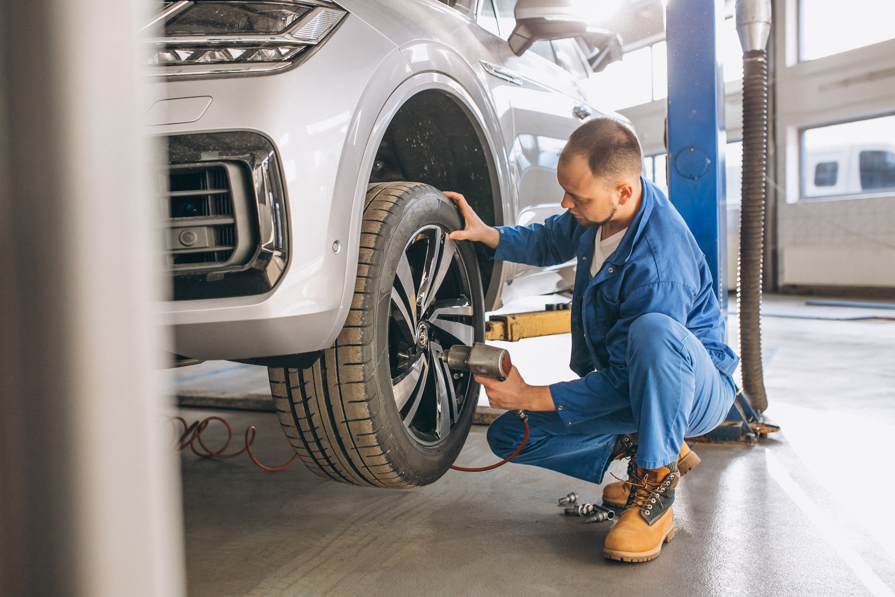  Auto mechanic checking car tyre